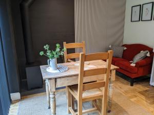 uma mesa de madeira com duas cadeiras e uma planta sobre ela em Self-Catering Suite in rural guest house 10 min to Islay Ferry Terminal em Ronachan