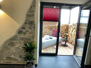 een kamer met een balkon, een bank en een raam bij Chalet-Ferienwohnung Schlossblick, 51 qm, Wellness/Fitness/Sauna – Bergrödelhof in Feilitzsch