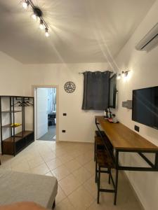 een woonkamer met een bureau en een klok aan de muur bij affittacamere in centro MUSCI' ROOMS e SUITES in Tortolì