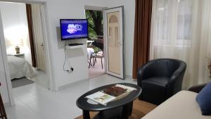 ein Wohnzimmer mit einem Tisch und einem TV. in der Unterkunft Apartments 101 in Kotor