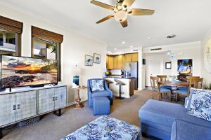 een woonkamer met een blauwe bank en een tv bij Kapalua Golf Villa 15T 7&8 in Kahana