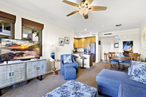 a living room with a blue couch and a tv at Kapalua Golf Villa 15T 7&8 in Kahana