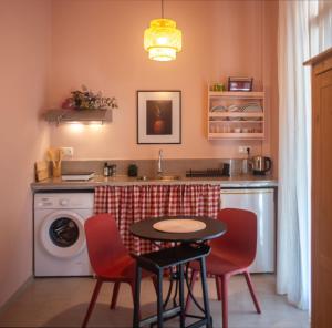 uma cozinha com uma máquina de lavar roupa, uma mesa e cadeiras em Nina's apartment em Lixouri