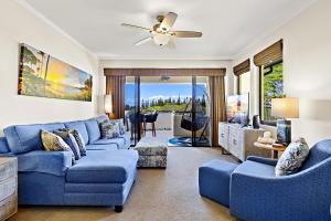 een woonkamer met blauwe banken en een plafondventilator bij Kapalua Golf Villa 15T 7&8 in Kahana