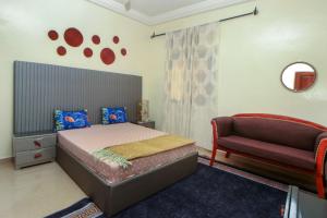 1 dormitorio con 1 cama y 1 sofá en Le "Grand Bleu", un bel appartement paisible, sûr et spatieux au cœur de la station balnéaire de Saly Portudal, en Saly Portudal