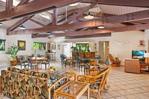a living room with couches and tables and chairs at Hololani B602 in Kahana