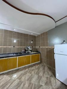 a kitchen with a white refrigerator and brown cabinets at Chez mimoun in Berkawe