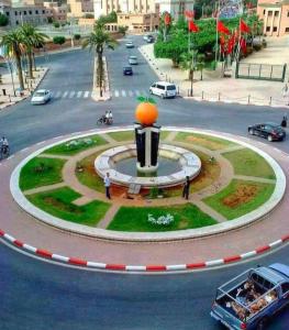 une fontaine avec une orange au milieu d'une rue dans l'établissement Chez mimoun, à Berkane