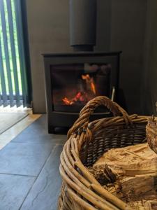 a fireplace in a living room with a basket at Self-Catering Suite in rural guest house 10 min to Islay Ferry Terminal in Ronachan