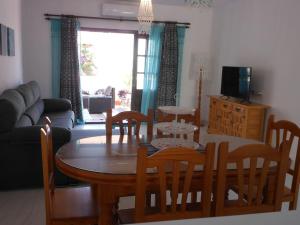 een woonkamer met een houten tafel en stoelen bij Las Palmeras del Cantal in Mojácar