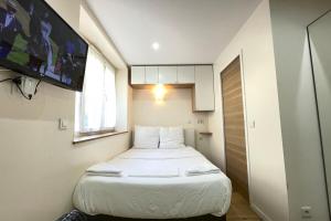 mały pokój z łóżkiem i telewizorem w obiekcie Cosy Appart Jouy N1 RER C 500 m w mieście Jouy-en-Josas