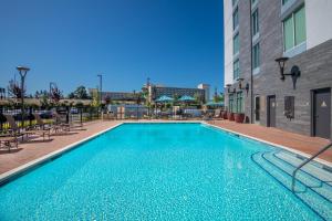 uma piscina com cadeiras e um edifício em Hyatt Place San Jose Airport em San Jose