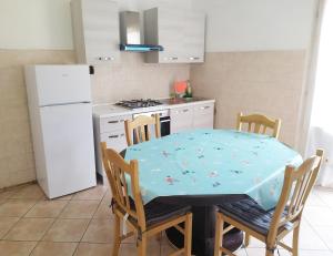 a kitchen with a table and chairs and a refrigerator at Levico Centrale Apartment in Levico Terme