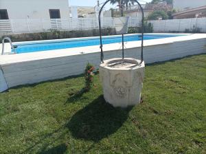 un planteur dans l'herbe à côté d'une piscine dans l'établissement Oasi del mare, à Granelli
