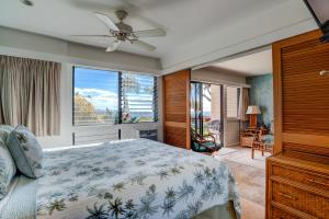 a bedroom with a bed and a large window at Hono Kai A7 in Kihei