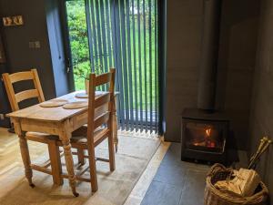 a table and chairs in a room with a fireplace at Self-Catering Suite in rural guest house 10 min to Islay Ferry Terminal in Ronachan