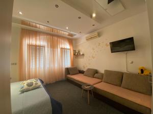 a living room with a couch and a bed at Studio apartment and rooms ADRIA in Vodice