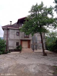 a large house with a tree in front of it at Mimoza Park House in Trabzon