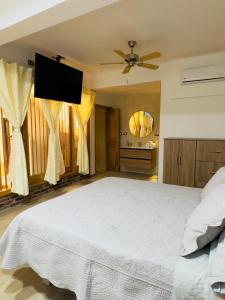 a bedroom with a large bed with a ceiling fan at Hotel Paso Realce in Guaduas