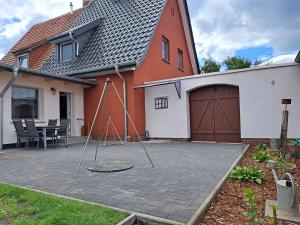 a patio in front of a house with a swing at Ferienhaus Mandelbäumchen in Barth