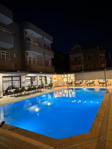 uma grande piscina à noite com iluminação azul em Soykan Hotel em Marmaris