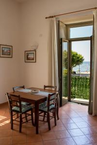 a dining room with a table and chairs and a sliding glass door at Uno sguardo sul mare in Maiori