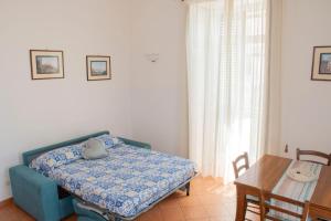 a bedroom with a blue bed and a table and a table and chairs at Uno sguardo sul mare in Maiori +9 photos