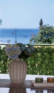 un vaso bianco con dei fiori sul tavolo di Casa Vacanze Uno sguardo sul mare a Maiori