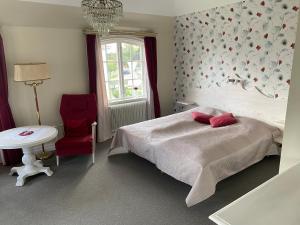 a bedroom with a bed and a table and a chair at Villa Blenda in Borgholm