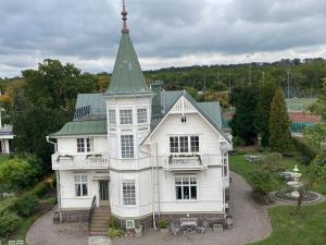 a large white house with a green roof at Villa Blenda in Borgholm