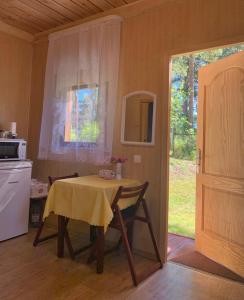 拉普梅日齊安斯的住宿－Zem Priedēm，厨房配有一张桌子,上面有黄色的桌布