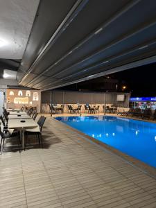 a swimming pool with tables and chairs in a building at Soykan Hotel in Marmaris