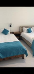 a bedroom with two beds with blue and white sheets at Lacul de argint in Gura Râului