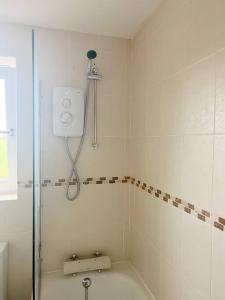 een badkamer met een douche en een bad bij Field House in Boroughbridge
