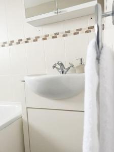 een witte badkamer met een wastafel en een spiegel bij Field House in Boroughbridge