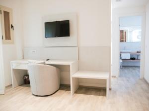 a white desk with a television on a wall at Hotel Bristol in Lido di Jesolo