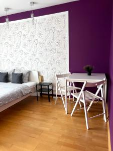 ルブリンにあるPokoje Rezydencja Parysaの白いテーブルと紫の壁のリビングルーム