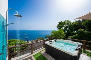 a bath tub on a balcony with a view of the ocean at Rays of sun - apartment in Positano