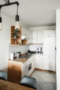 La cuisine est équipée de placards blancs et d'un four avec plaques de cuisson. dans l'établissement Apartment 252, Oberharz, mit Schwimmbad und Sauna, à Braunlage
