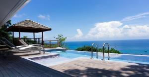 a swimming pool with a view of the ocean at Naroua Villas in Ko Tao