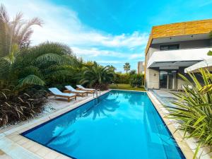 una piscina con due sedie e una casa di Villa Miami a Çeşme