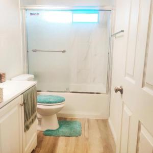 a white bathroom with a toilet and a shower at Nice Private Room Near Red Rock & Las Vegas Strip in Las Vegas