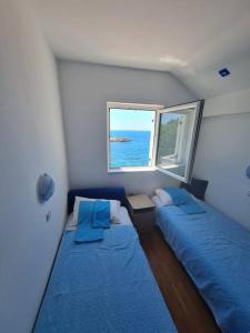 two beds in a small room with a window at The View Sveti Stefan V2 in Sveti Stefan