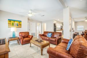 a living room with leather furniture and a table at Blue Horizon HUGE Private Pool and yard with Outside shower! in Port Aransas