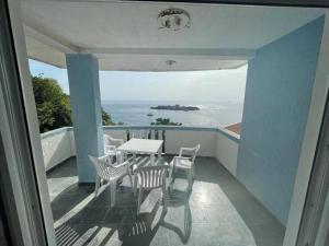 a balcony with a table and chairs and the ocean at The View Sveti Stefan V2 in Sveti Stefan
