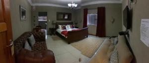 Botha’Sig Gastehuis في Daniëlskuil: غرفة معيشة مع أريكة وسرير