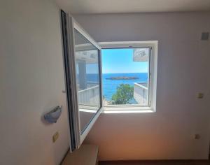 a room with a window with a view of the ocean at The View Sveti Stefan V2 in Sveti Stefan