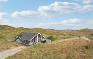 a small house on a hill in a field at Pet Friendly Home In Hvide Sande With House Sea View in Havrvig