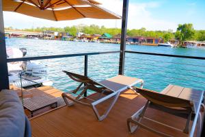 a deck with two chairs and an umbrella on a boat at Pirates Nest Cottages in Ulcinj