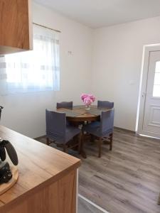a dining room table with chairs and a vase of flowers at Miljenko&Miljenka in Supetarska Draga +10 photos